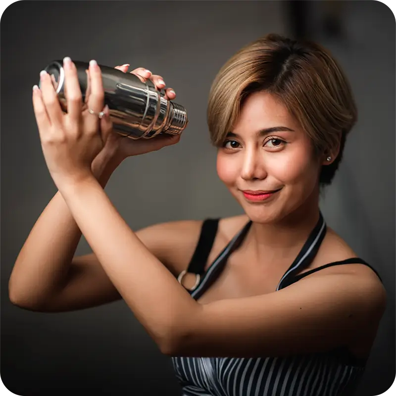 Woman demonstrating how to use a cocktail shaker