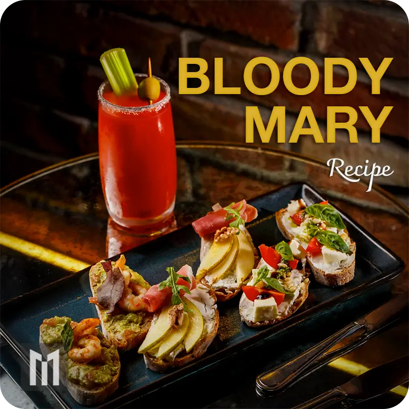 Bloody Mary with celery and olive garnish next to crostini with shrimp, prosciutto, pear, feta, and tomato.