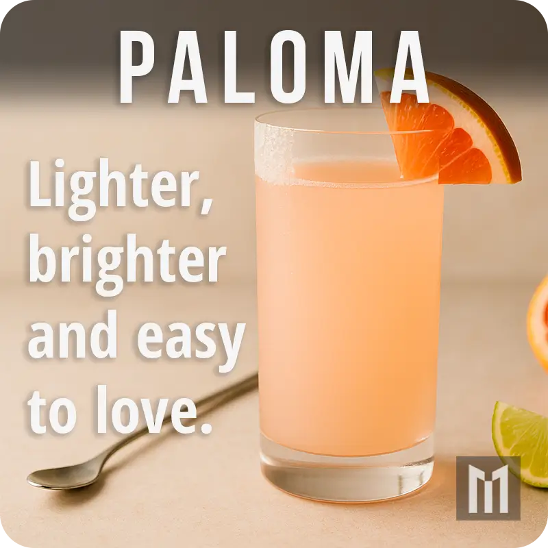 Paloma cocktail with a grapefruit wedge and a half-salted rim, styled simply with a silver bar spoon and citrus slice.